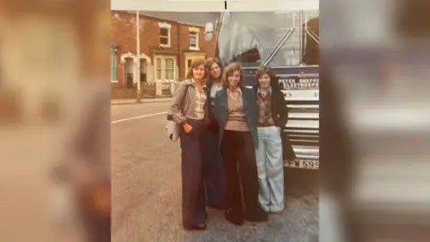 Christine Walker Four teenage girls standing in front of a coach in 1975