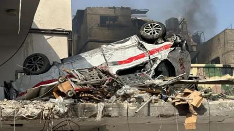 AFP File photo showing a damaged ambulance lying upside down outside Kamal Adwan hospital in Beit Lahia, northern Gaza (26 October 2024)