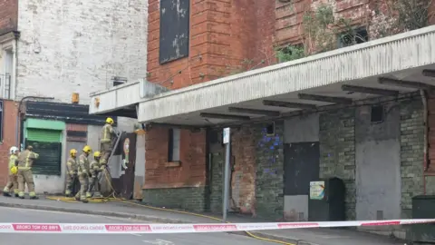 Fire crews using a ladder to access the rear of the building