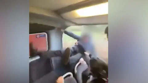 A screenshot image of two young boys dressed in dark school uniform falling from a window.
