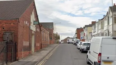 The view down Grant street, with houses on the right of the street and other non residential building on the other side.