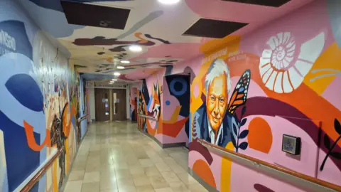 A corridor with colourful pain on the walls 