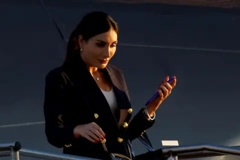 Reuters Laura Loomer exiting a plane, looking down and holding a phone in her hand