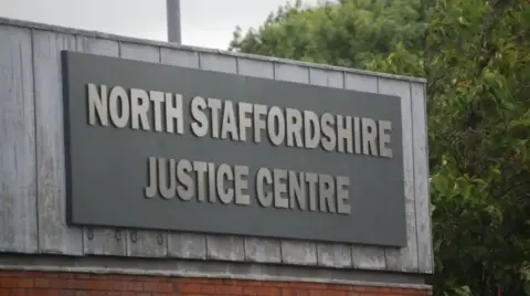 A large grey sign which reads North Staffordshire Justice Centre