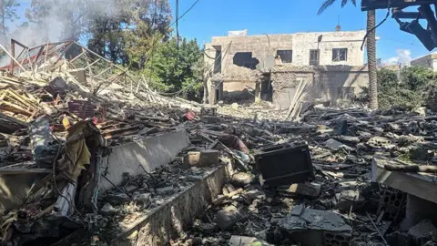 KAWNAT HAJU / AFP via Getty Images A photograph shows the aftermath of an Israeli strike that targeted a house near a Lebanese army checkpoint (unseen) in the area of Aamriyeh, south of Tyre.