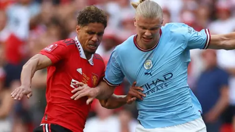 Reuters Manchester United's Raphael Varane in action with Manchester City's Erling Haaland