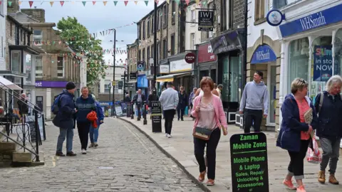 Getty Images A cobbled street with a wide pavement on the right of the image and a number of shops in Skipton in North Yorkshire