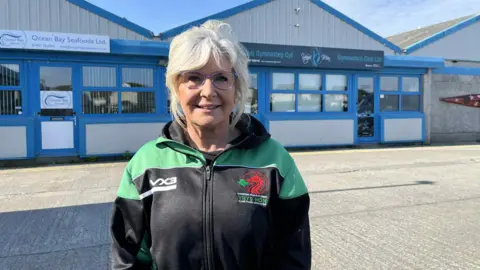 Catherine Rowley in an Island Games jacket outside of Ynys Mon Gymnastics Club.