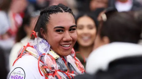 Haineala Lutui after the match. She is smiling and looking towards the camera and has a garland around her neck. 
