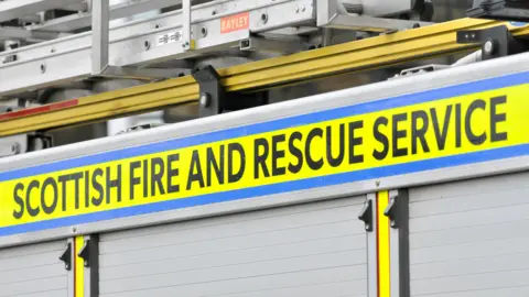 Getty Images The side of a fire engine with the Scottish Fire and Rescue Service name in black lettering on a bright yellow background