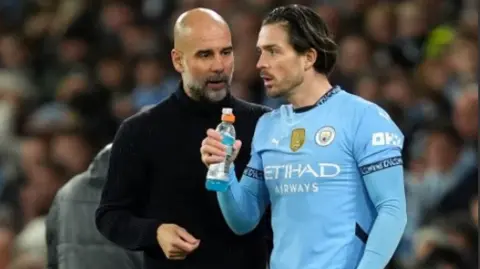 PA City manager Pep Guardiola talks to Jack Grealish on the touchline before he comes on as a sub against Spurs