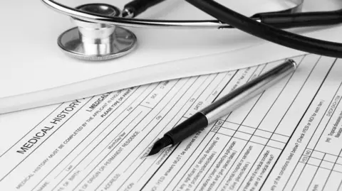 A stethoscope and a pen lie on top of a document titled medical history