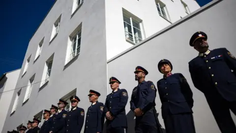 EPA/Shutterstock Austrian police officers stand in front of the newly opened police station in the building where Adolf Hitler was born in 1889, in Braunau am In