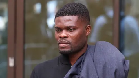 EPA Former Arsenal footballer Thomas Partey departs the Westminster Magistrates Court in London, Britain, 05 August 2025. Thomas Partey wears a black zip-up collared sweater.