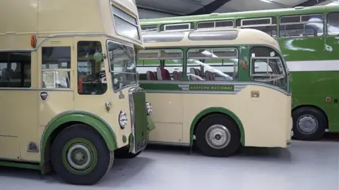 Jamie Niblock/BBC A side view of three buses that are a mix of cream and green