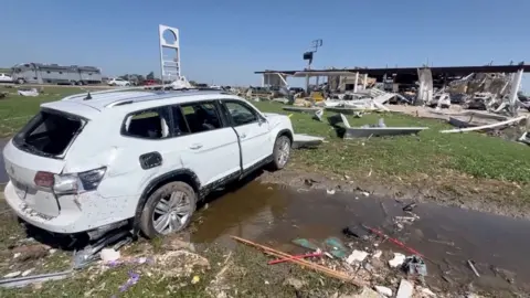 SUV destroyed in front of a damaged gas station after a tornado in Valley View, Texas