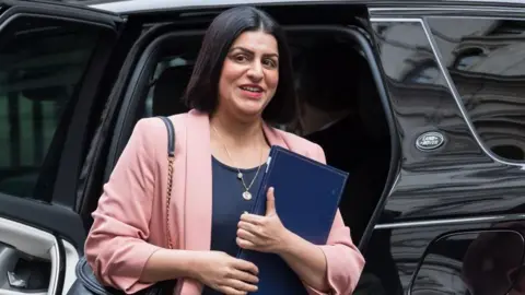 Wiktor Szymanowicz/Getty Images Secretary of State for Justice Shabana Mahmood steps out of a taxi at Downing Street to attend the weekly Cabinet meeting in London. She is holding a blue folder and wearing a pink blazer over a navy top.