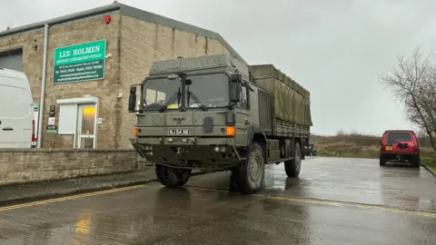 An army truck arrives at a rest centre
