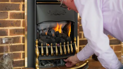 Getty Images Older man turns on an electric fire