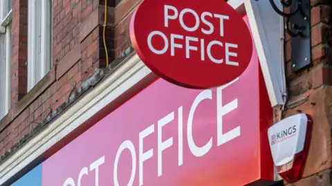 The red and white livery of the Post Office outside a branch.