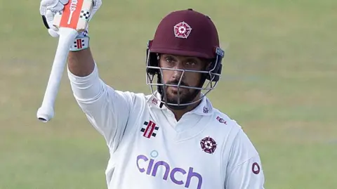 Saif Zaib raises his bat to the crowd
