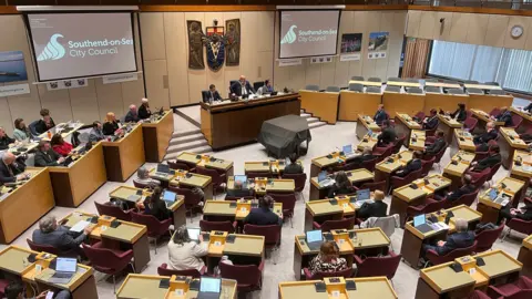 Southend Council chamber. Councillors are sitting at rows of desks in a semi-circular configuration.