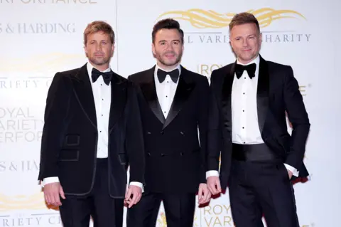 PA Media Westlife posing in dinner jackets and bow ties