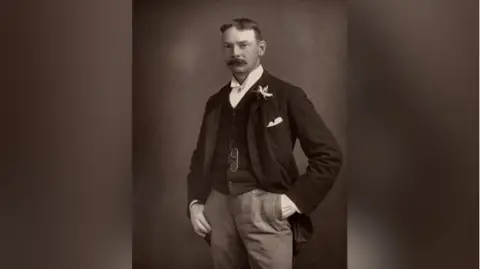 Universal History Archive/Getty Images An archive image of Jerome Klapka Jerome from The Cabinet Portrait Gallery. He is standing in front of the camera with his left hand in his pocket and his his right thumb tucked in the other pocket.