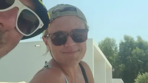 Alex Griffiths and his wife Danni both wear dark glasses and hats in a selfie