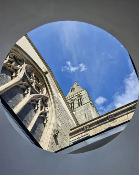 Ranjit Singh Chaggar A cathedral spire seen through a round window