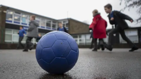 PA Media Children playing at school