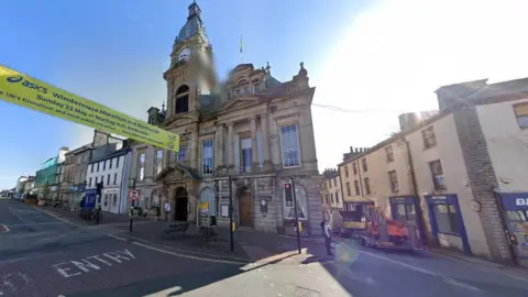 Google An historic town hall, with a clock tower, situated on the streets of Kendal