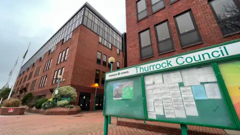 Thurrock Council offices. There is a green sign saying Thurrock Council outside the buildings.
There are notices on the greenboard