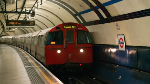 Getty Images A red Bakerloo line train arrives at Lambeth North station, with "Queen's Park" displayed as its destination.