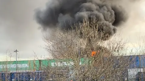 Finn Johnson Stear A large black cloud of smoke is coming from a fire in the industrial area