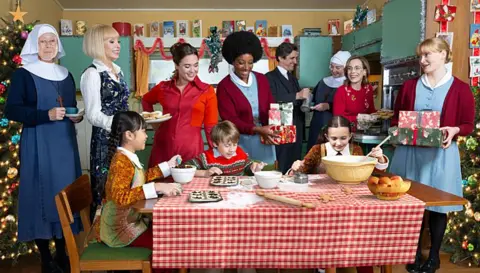 BBC/Neal Street Productions Call the Midwife cast Christmas scene, with characters cooking around a table in a kitchen