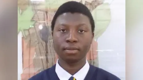 Handout Eighteen-year-old Matt Sibanda in his school uniform. He has short, black hair and is wearing a navy jumper, a white shirt and a navy and yellow tie.