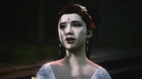 Game Science A CGI of a spider sister from the game Black Myth: Wukong. She has intricate blue makeup on her forehead and temples and is wearing a white dress