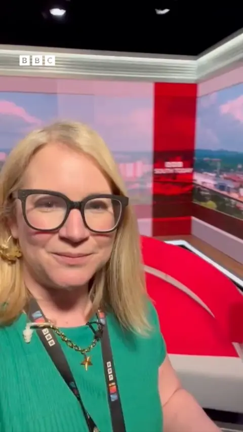 A woman with blonde hair wearing a green top