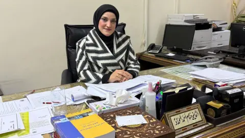 Khitam Haddad sitting at a desk - appointed deputy justice minister in 2023, under the Assad regime