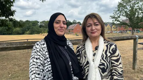 From left to right, Tahra Shah and Attia Aslam look straight at the camera