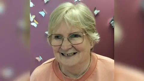 Butterflies Bereavement Support Julie Lamont, wearing glass and an orange top