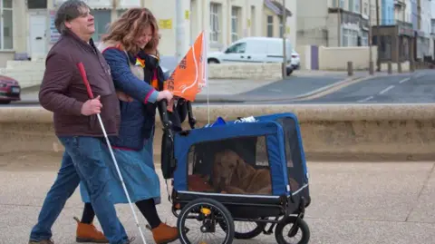 Sarah Summerton Mark Fielding, Gemma Fairhurst and Ian in his doggy pram walking along Blackpool Promenade.