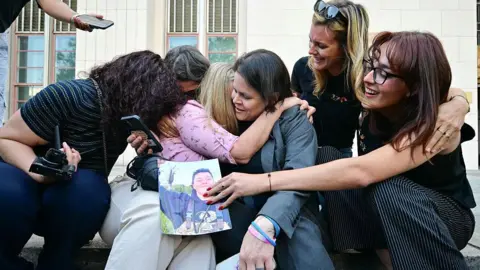 AFP via Getty Images A plaintiffs' attorney for the Social Media Victims Law Center embracing family members of victims on the steps outside the Los Angeles Superior Court on Wednesday.