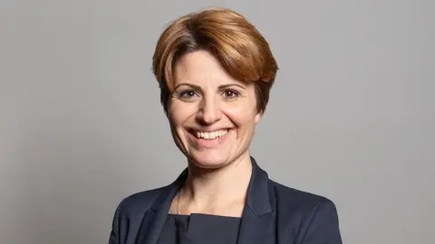 UK Parliament Emma Hardy MP she has brown short hair and is wearing a dark blue jacket and shirt