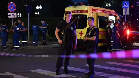 Armed Moscow police stand guard in front of an ambulance near the scene of an explosion near the centre of the city.