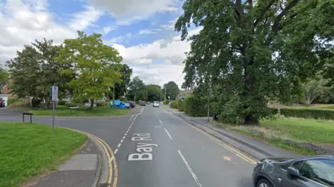 Google a Google Street View screenshot showing the approximate location of the accident. It is a T unit in a residential street with grass and trees on the sides of the roads.