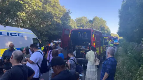 Reuters A rural road filled with passengers from the train and emergency service vehicles