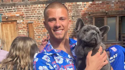 Emma Mildwater Harry Clarke holding Teddy and smiling