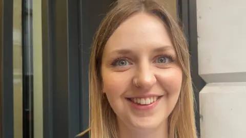 A young blond woman smiles